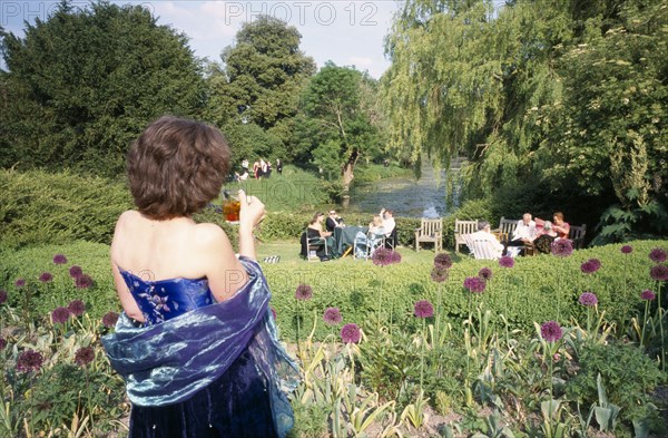 ENGLAND, East Sussex, Glyndebourne, Opera attendees enjoying picnics in the gardens during interval.
