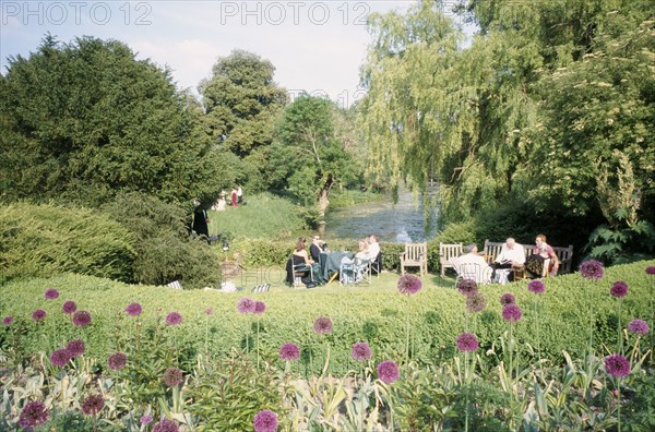 ENGLAND, East Sussex, Glyndebourne, Opera attendees enjoying picnics in the gardens during interval.