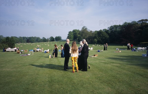 ENGLAND,  East Sussex, Glyndebourne, Opera attendees enjoying picnics in the gardens during performance interval