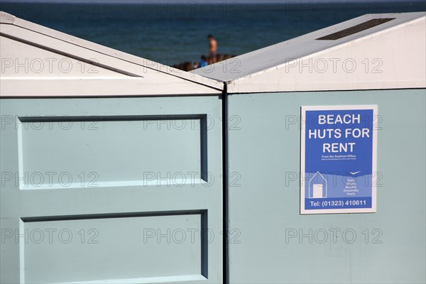 ENGLAND, East Sussex, Eastbourne, Beach huts below the seafront promenade and Hotels.