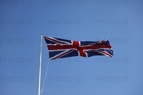 CLIMATE, Wind, Flags, British Union Jack flag flying in wind against blue sky.