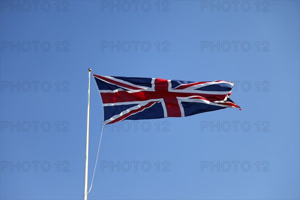 CLIMATE, Wind, Flags, British Union Jack flag flying in wind against blue sky.