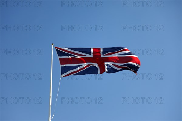 CLIMATE, Wind, Flags, British Union Jack flag flying in wind against blue sky.