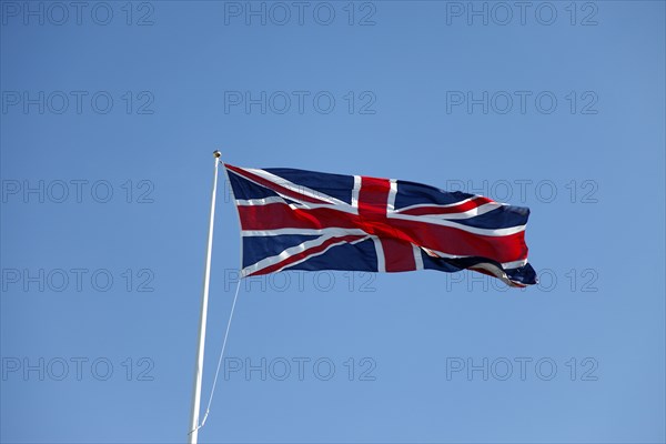 CLIMATE, Wind, Flags, British Union Jack flag flying in wind against blue sky.