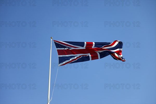 CLIMATE, Wind, Flags, British Union Jack flag flying in wind against blue sky.