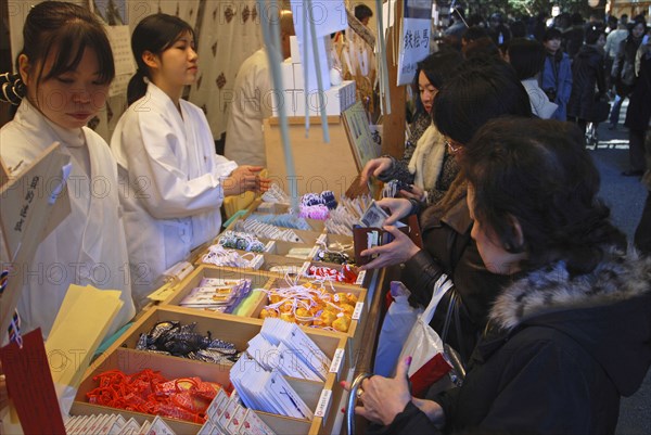 JAPAN, Honshu, Tokyo, "ingumae - Meijijingu shrine, New Years worshippers buying omamori good luck charms for the New year"