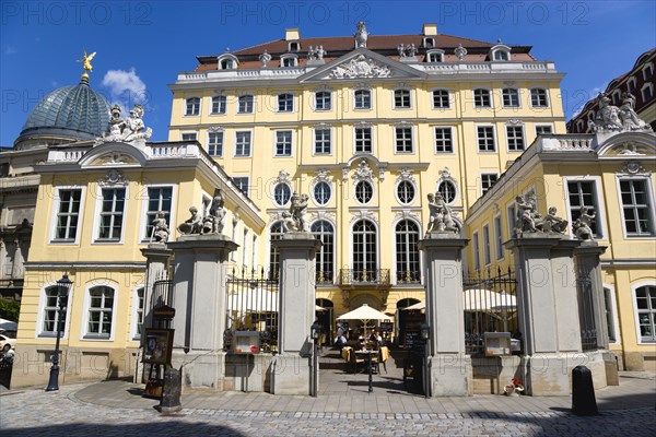 GERMANY, Saxony, Dresden, The glass dome of the Academy of Arts built 1891-94 on the Brhl Terrace by Constantin Lipsius in the style of the Neo-Renaissance behind the Baroque courtyard entrance to the Coselpalais which is now a restuarant busy with diners seated at tables under umbrellas.