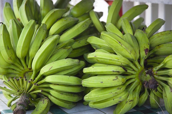 WEST INDIES, Grenada, Carriacou, Hillsborough Bundles of green bananas on a stall in the main street.