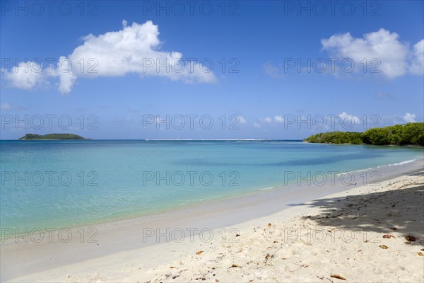 WEST INDIES, Grenada, Carriacou, Waves breaking on Paradise Beach at L'Esterre Bay with the turqoise sea and Sandy Island sand bar beyond.