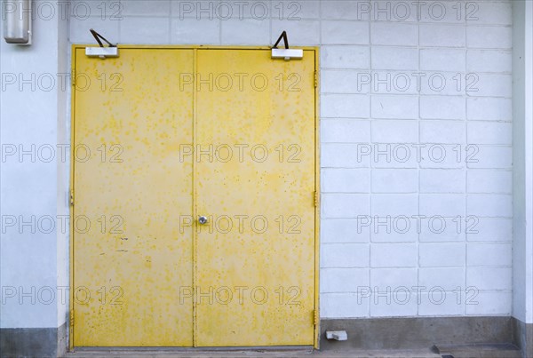 WEST INDIES, St Vincent & The Grenadines, Union Island, Closed metal yellow doors set in a white wall in Clifton.