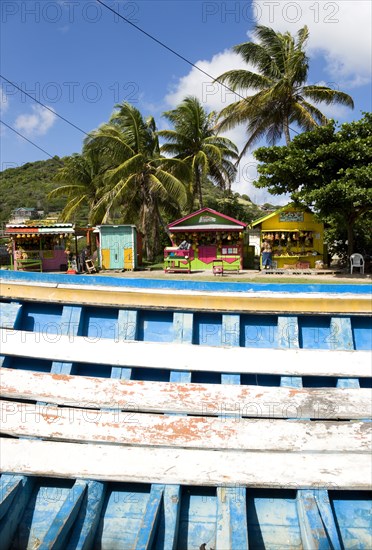 WEST INDIES, St Vincent & The Grenadines, Union Island, The fruit and vegetable market in Mulzac Square in the capital Clifton seen over a beached fishing boat.