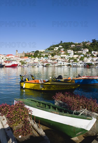 WEST INDIES, Grenada, St Georges, The Carenage harbour in the capital with houses lining the hillside and water taxis moored.
