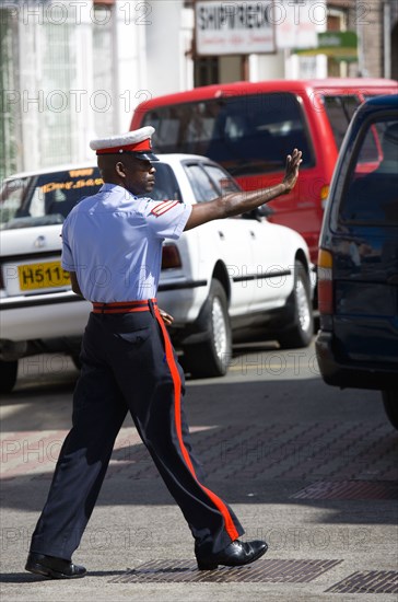 WEST INDIES, Grenada, St Georges, Corporal in the Royal Granada Police Force directing traffic at rush hour in the capital.