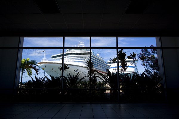 WEST INDIES, Grenada, St George, The cruise ship liners Caribbean Princess and Aida Aura docked at the Cruise Ship Terminal in the capital St Georges seen through the window of the ternminal building.