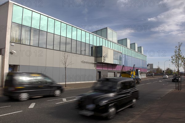 IRELAND, North, Belfast, "Falls Road, Exterior of the refurbished Falls Swimming Baths with black taxi cabs passing by."