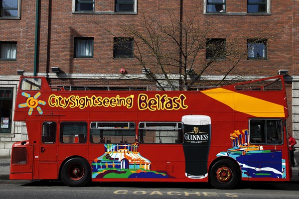 IRELAND, North, Belfast, "College Avenue, Red open top double deck tour bus outside Jurys hotel."