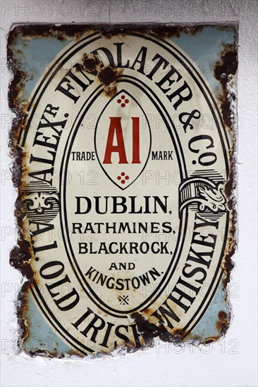 IRELAND, North, Belfast, "Cathedral Quarter, Commerical Court, Old metal whiskey sign decorating the exterior of the Duke of York Public House."