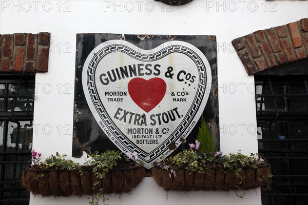 IRELAND, North, Belfast, "Cathedral Quarter, Commerical Court, Old metal Red Heart Belfast Bottled Guinness sign decorating the exterior of the Duke of York Public House"