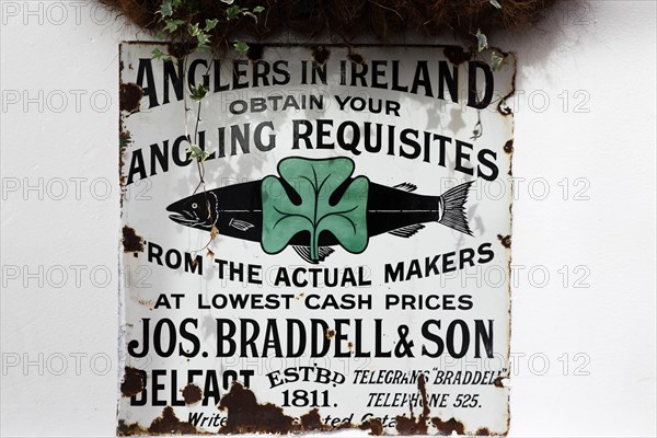 IRELAND, North, Belfast, "Cathedral Quarter, Commerical Court, Old metal fishing permit sign decorating the exterior of the Duke of York Public House."