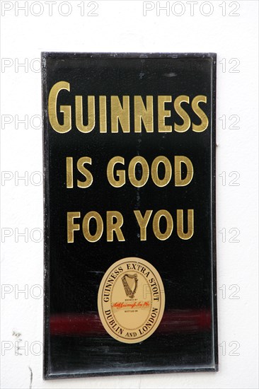 IRELAND, North, Belfast, "Cathedral Quarter, Commerical Court, Old metal Guinness sign decorating the exterior of the Duke of York Public House."