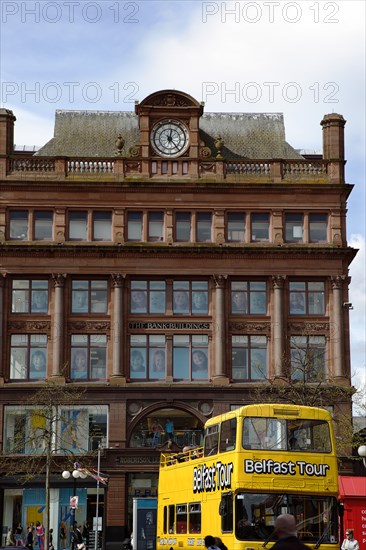 IRELAND, North, Belfast, "Castle Street Bank Buildings, former bank of the 4 Johns, now a retail clothing store. Yellow open top tour bus in foreground."