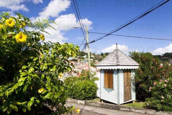 WEST INDIES, Grenada, St George, Colourful sentry post set amongst flowering plants on the road up from the capital to Fort George overlooking the capital.