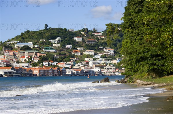 WEST INDIES, Grenada, St George, The hillside buildings and waterfront of the Carenage in the capital St Georges seen from Pandy Beach beside Port Louis Marina.