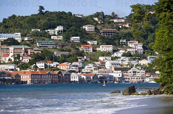 WEST INDIES, Grenada, St George, The hillside buildings and waterfront of the Carenage in the capital St Georges seen from Pandy Beach beside Port Louis Marina.