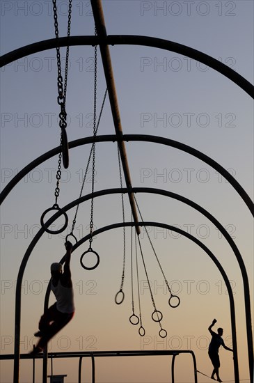 USA, California, Los Angeles, "Silhouetted Gymnasts on the rings, Santa Monica beach"