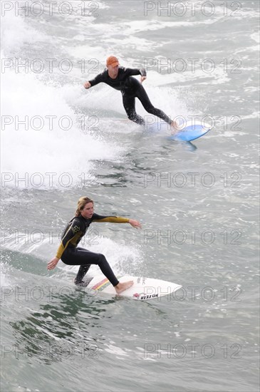 USA, California, Los Angeles, Riding the surf at Huntington Beach