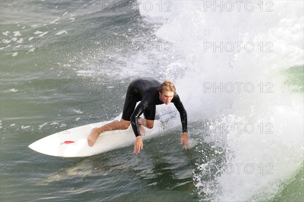 USA, California, Los Angeles, Surfer riding waves at Manhattan Beach