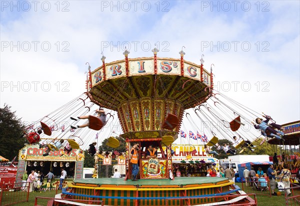 ENGLAND, West Sussex, Findon, Findon village Sheep Fair Children in motion riding on a swing carousel.