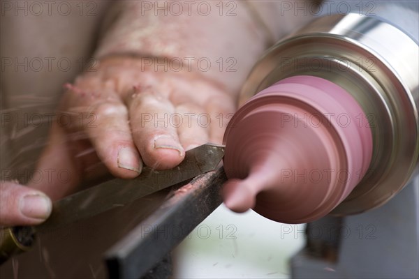 ENGLAND, West Sussex, Findon, Findon village Sheep Fair Man using a wood lathe with a chisel cutting into the spinning wood.