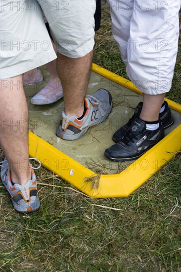 ENGLAND, West Sussex, Findon, Findon village Sheep Fair People walking through a foot bath at a Bio Security Point to help prevent spread of foot and mouth disease.