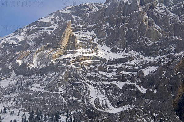 CANADA, Alberta , Kananaskis, A light sprinkling of snow makes it easier to see the complex rock formation of the south face of Mount Evan Thomas.