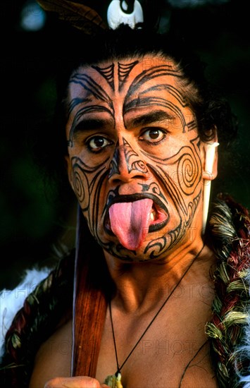 NEW ZEALAND, North Island, Rotorua, Head and shoulders portrait of Maori native man with tattoos and body paint.