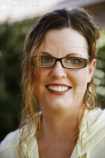 PEOPLE, Women, Young, Portrait of a mid adult woman smiling wearing high magnification glasses.
