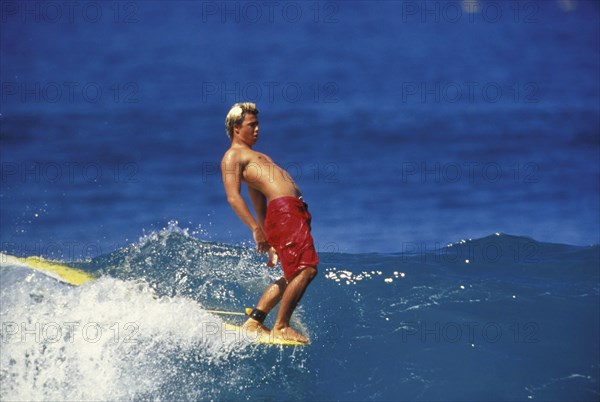 SPORT, Sea, Surfing, "Surfer hangs ten.  Male surfer walks to the point of the board and hangs ten toes over the end, arching backwards for balance."