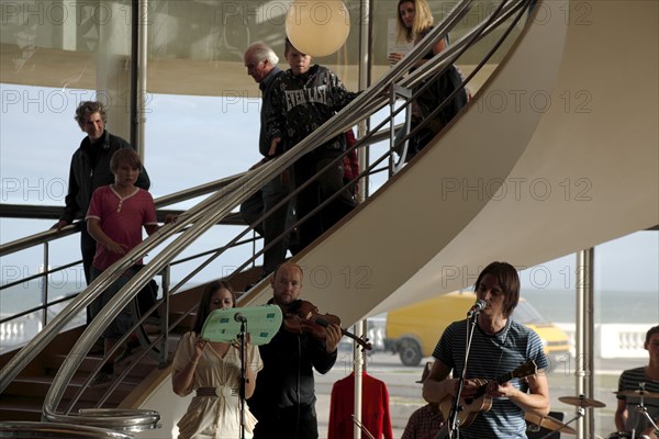 ENGLAND, East Sussex, Bexhill on Sea, De La Warr pavilion. Art Deco style building housing art gallery and theatre. Band performance under the stairwell from the Wilkomen Collective group including the Leisure Society.