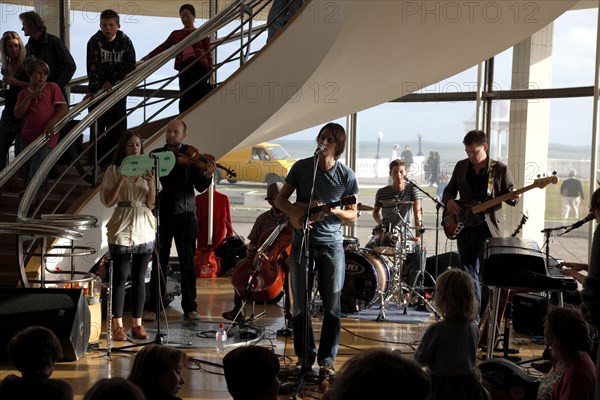 ENGLAND, East Sussex, Bexhill on Sea, De La Warr pavilion. Art Deco style building housing art gallery and theatre. Band performance under the stairwell from the Wilkomen Collective group including the Leisure Society.