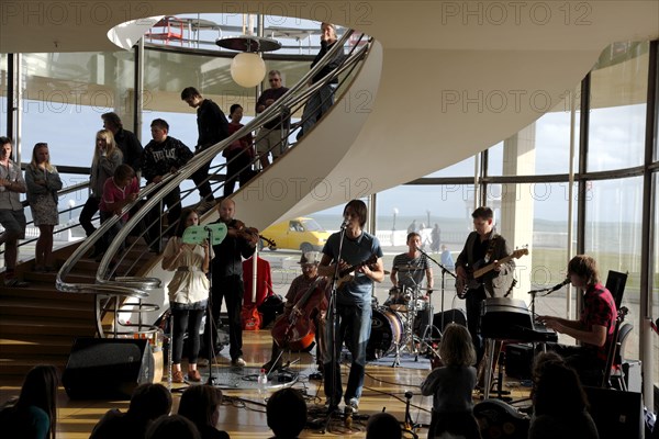 ENGLAND, East Sussex, Bexhill on Sea, De La Warr pavilion. Art Deco style building housing art gallery and theatre. Band performance under the stairwell from the Wilkomen Collective group including the Leisure Society.