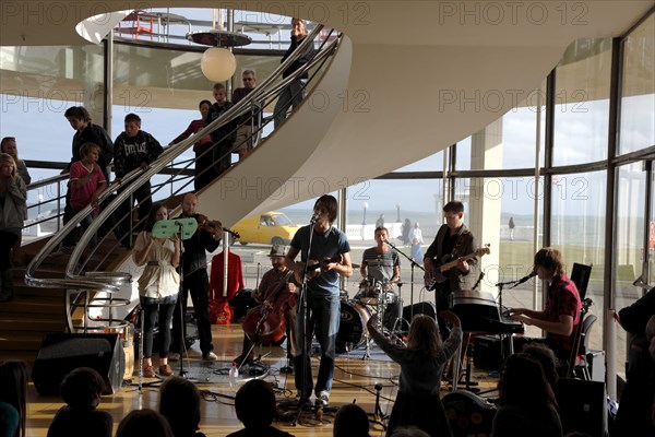 ENGLAND, East Sussex, Bexhill on Sea, De La Warr pavilion. Art Deco style building housing art gallery and theatre. Band performance under the stairwell from the Wilkomen Collective group including the Leisure Society.