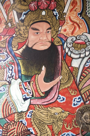 THAILAND, North, Chiang Mai, Pung Tao Gong Ancestral Temple. Close up of a colourful mural depicting a male deity.