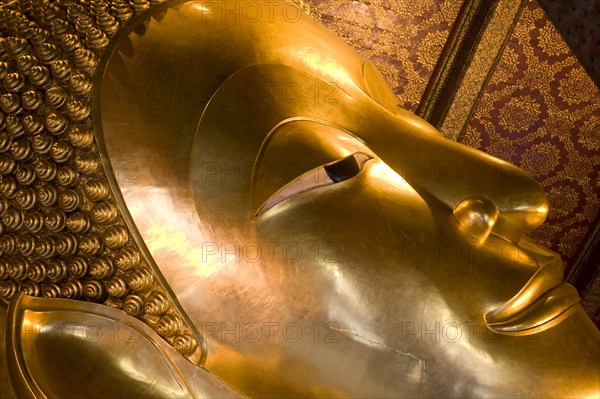 THAILAND, Central, Bangkok, Wat Pho also known as Wat Phra Chetuphon. Close up of the face of the large reclining buddha statue.
