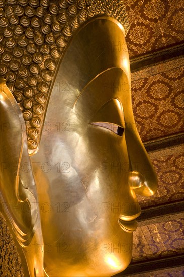 THAILAND, Central, Bangkok, Wat Pho also known as Wat Phra Chetuphon. Close up of the face of the large reclining buddha statue.