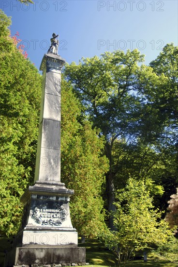 USA, New York State, Cooperstown, "Monument to James Fenimore Cooper topped with statue of Natty Bumpo, hero of ""Leatherstocking Tales"", in local cemetary."