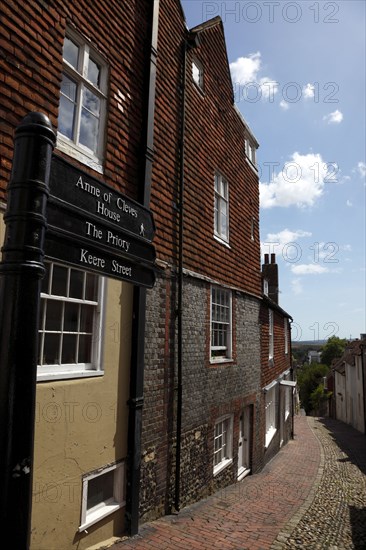 ENGLAND, East Sussex, Lewes, "High Street, Keere Street cobbled pathway with traditional buildings."