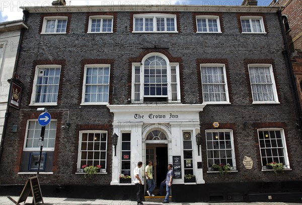 ENGLAND, East Sussex, Lewes, "High Street, Crown Inn Hotel and Bar. Featured on hotel inspectors tv programme. Smokers standing outside entrance smoking."