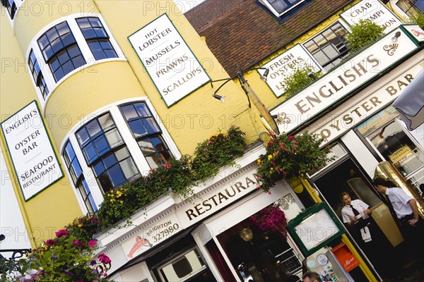 ENGLAND, East Sussex, Brighton, The Lanes Englishs Oyster Bar and Seafood Restaurant exterior with a waitress carrying a cup of coffee and a waiter by the entrance.