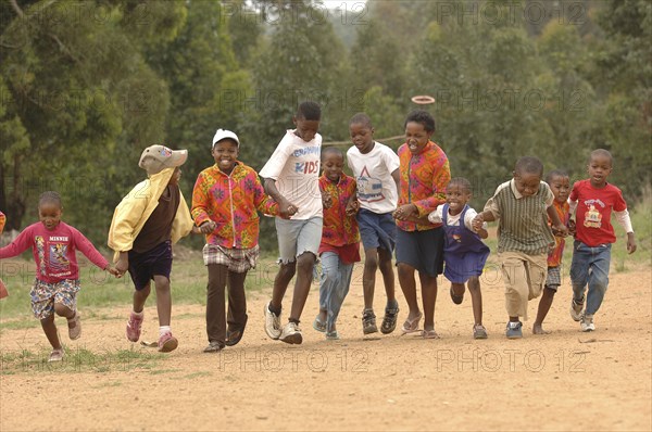 AFRICA, Children , Playing, School Children running on dirt road.